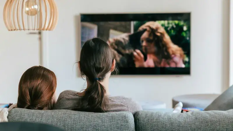 Pareja viendo televisión en el sofá de su sala