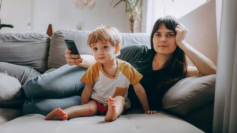 Persona en el sofá con el mando del televisor